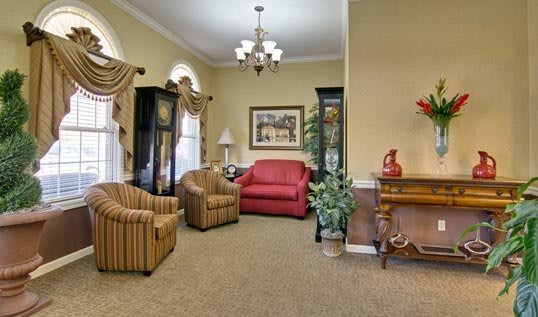 A cozy living room featuring a red sofa, striped armchairs, and elegant decor.