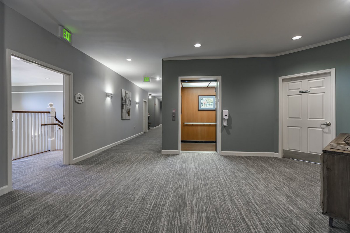 A modern hallway featuring an open elevator and contemporary design elements.