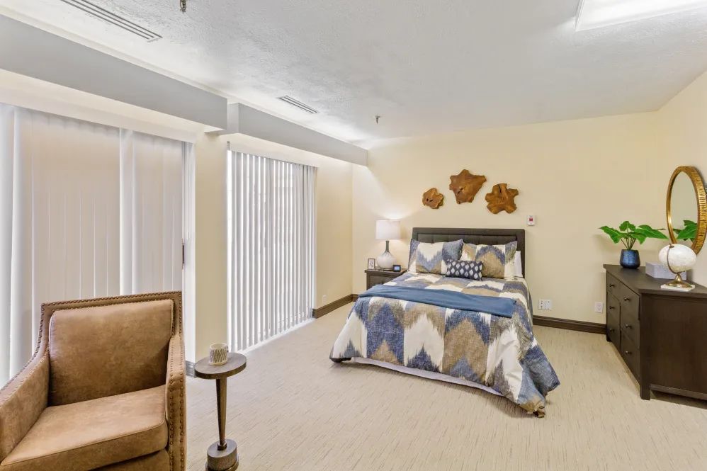 A cozy bedroom with a neatly made bed, a reading lamp, and stylish decor.