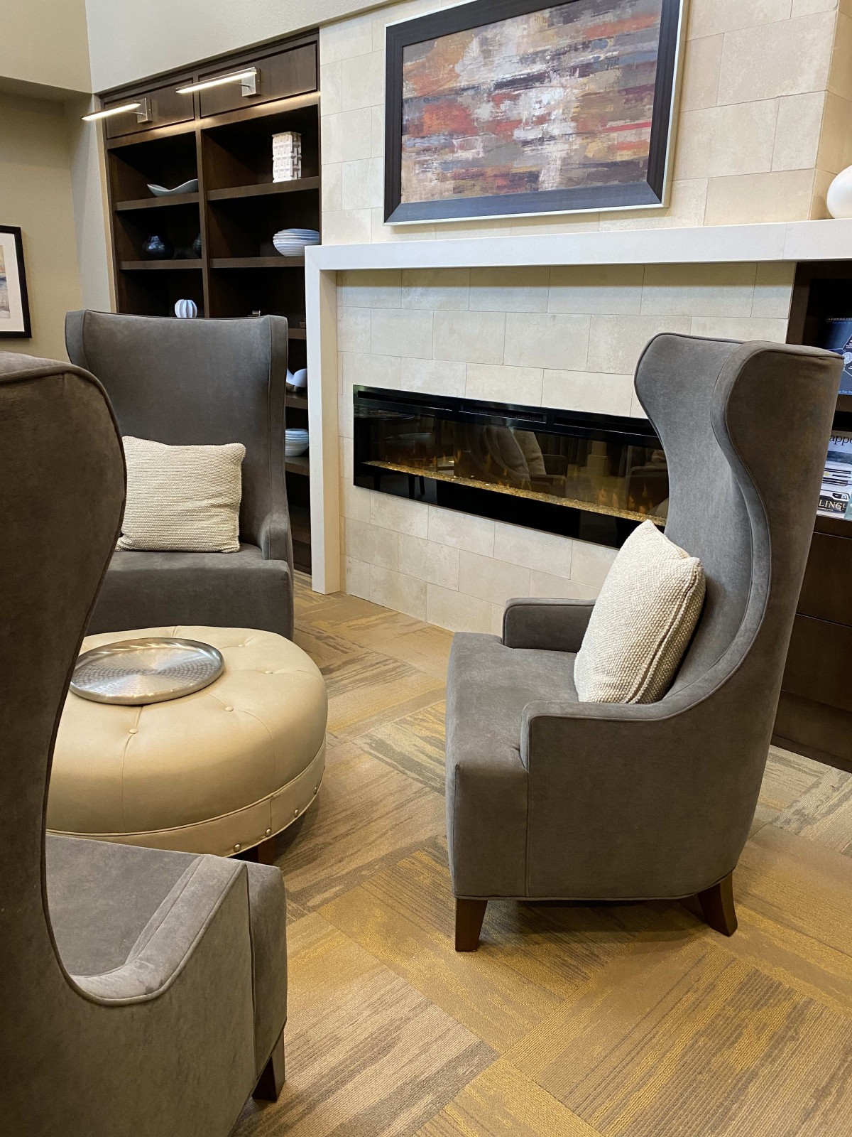 A modern living room with comfortable chairs and a fireplace.