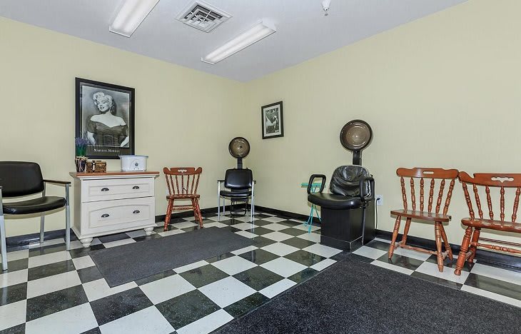 A retro-style barbershop interior with checkered flooring and vintage decor.