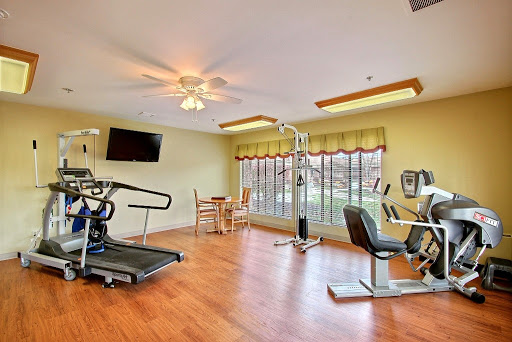 A well-lit gym area featuring various fitness equipment, perfect for indoor workouts.