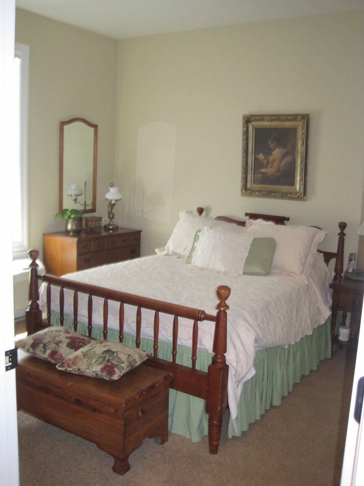 A cozy bedroom with traditional wooden furniture and neutral decor.