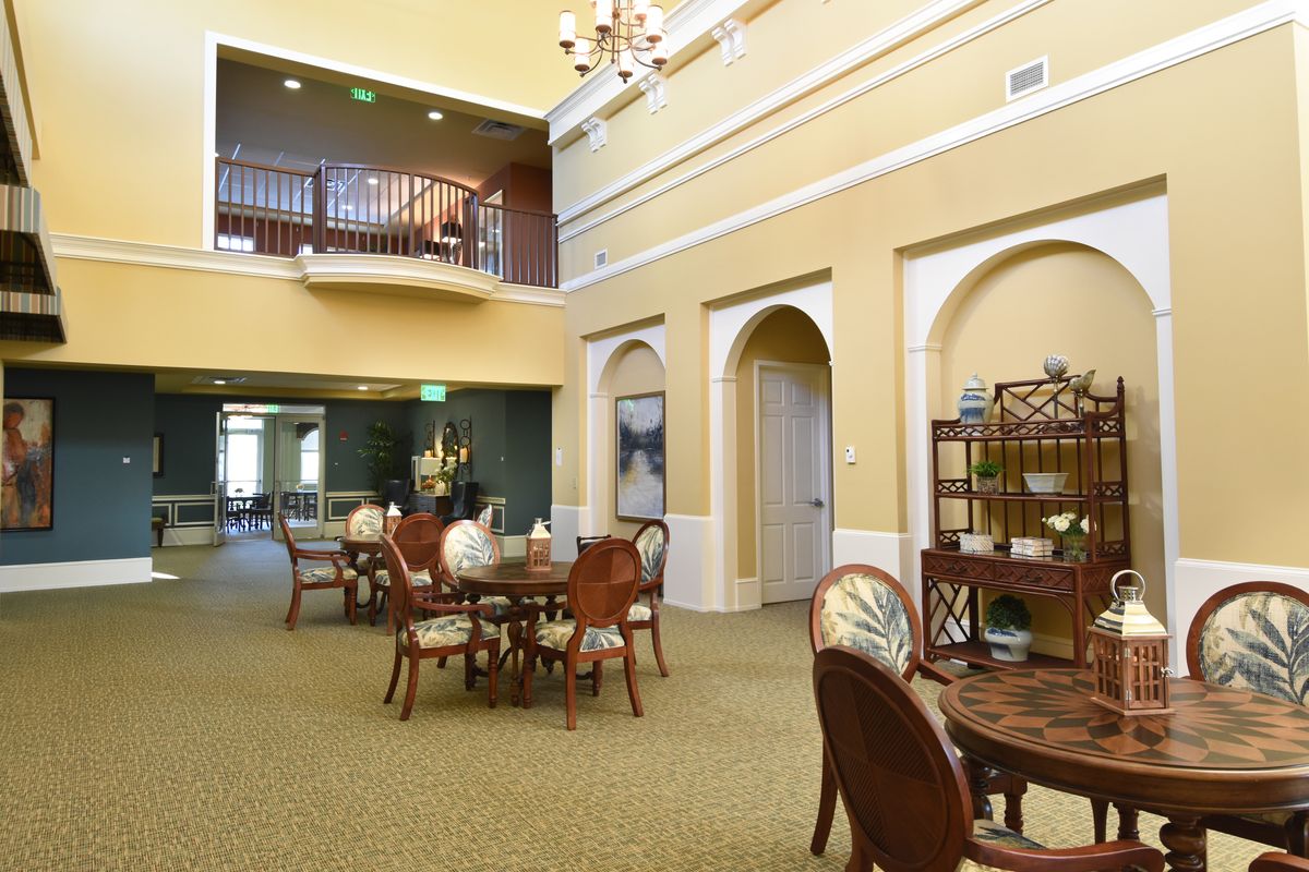 A spacious and elegantly decorated interior with tables and chairs set up in a dining area.