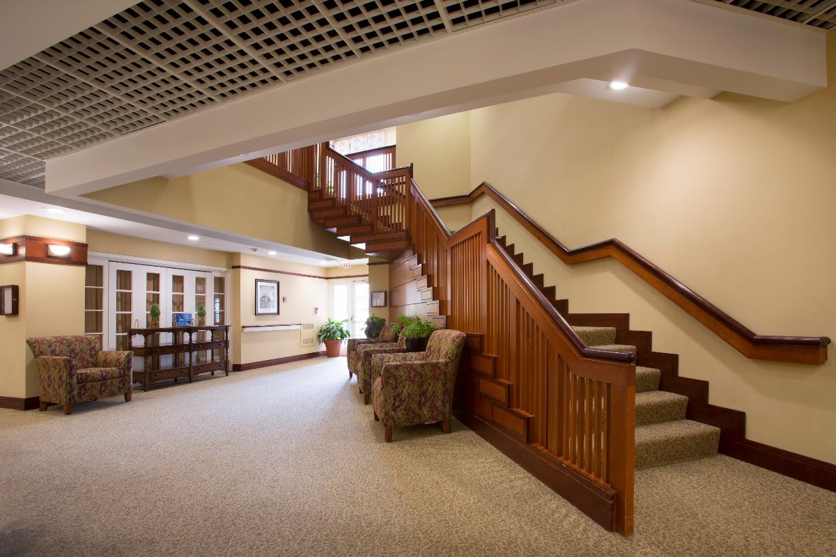 A spacious interior with a wooden staircase and comfortable seating.