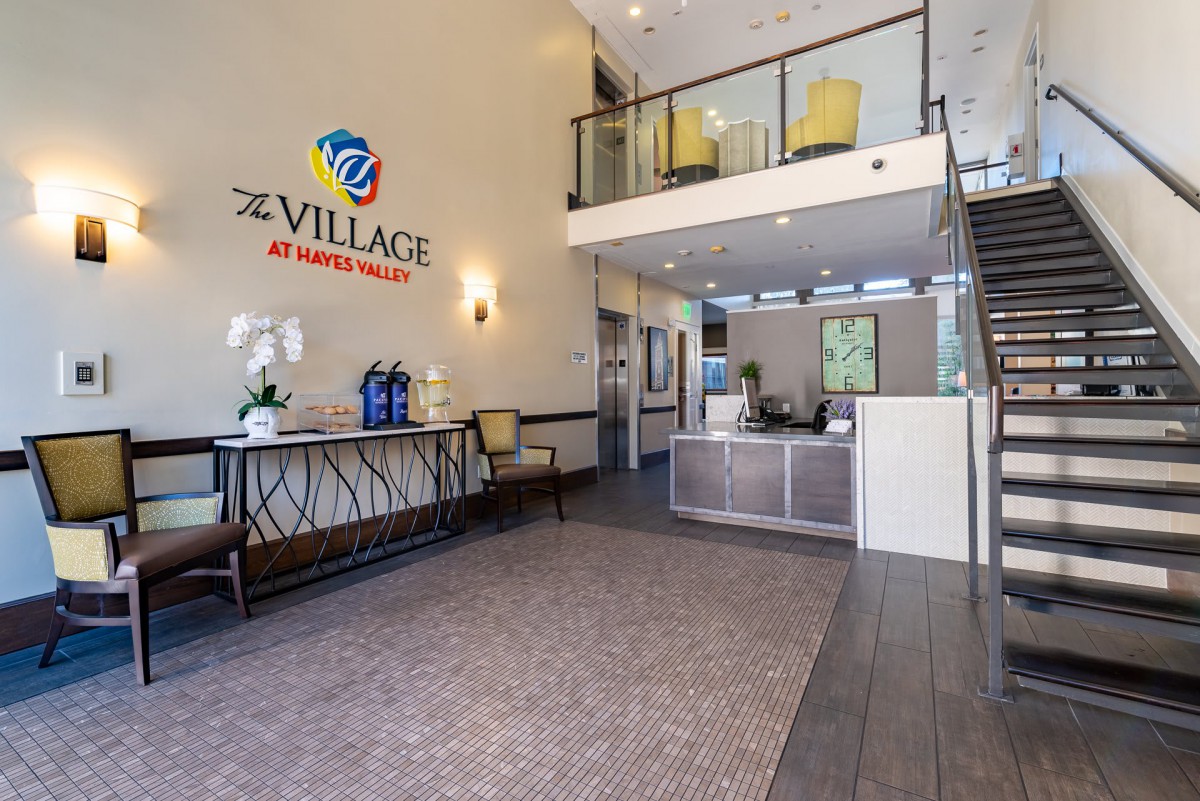 Modern lobby area of a business or residential building with reception desk and seating.