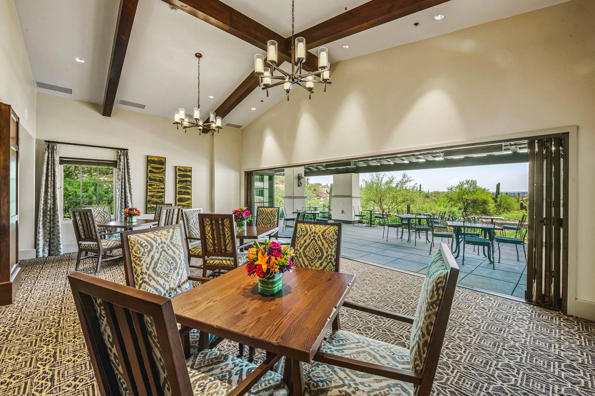 A spacious dining room with elegant furniture and a view of the outside patio.