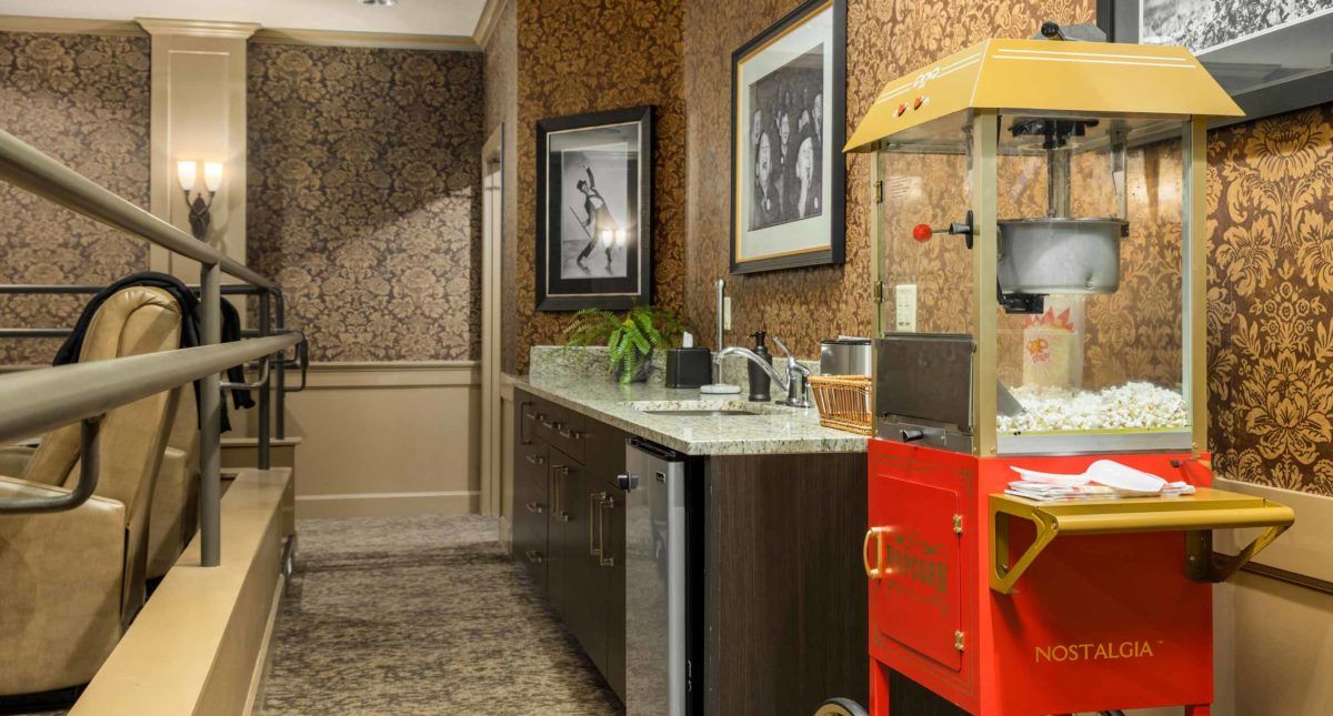 A cozy kitchen corner featuring a countertop with a popcorn machine and framed pictures.