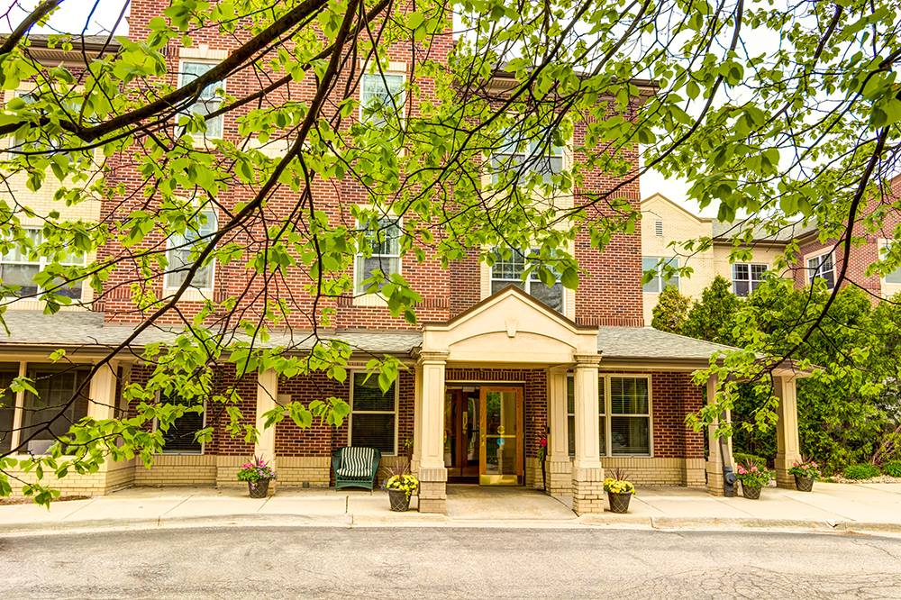A view of a brick building entrance surrounded by trees.