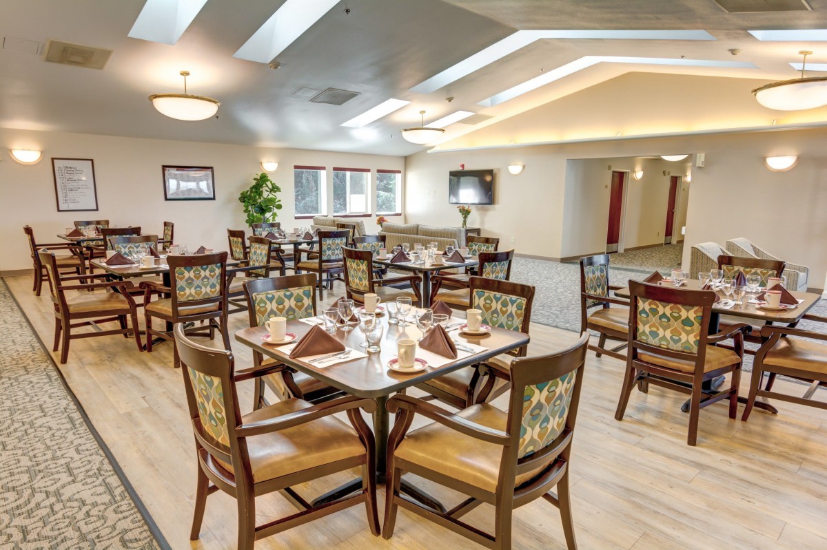 A well-lit dining area with modern decor, featuring neatly arranged tables and chairs.