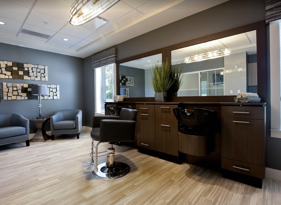 A modern and stylish hair salon interior with comfortable chairs, large mirrors, and sleek styling stations.