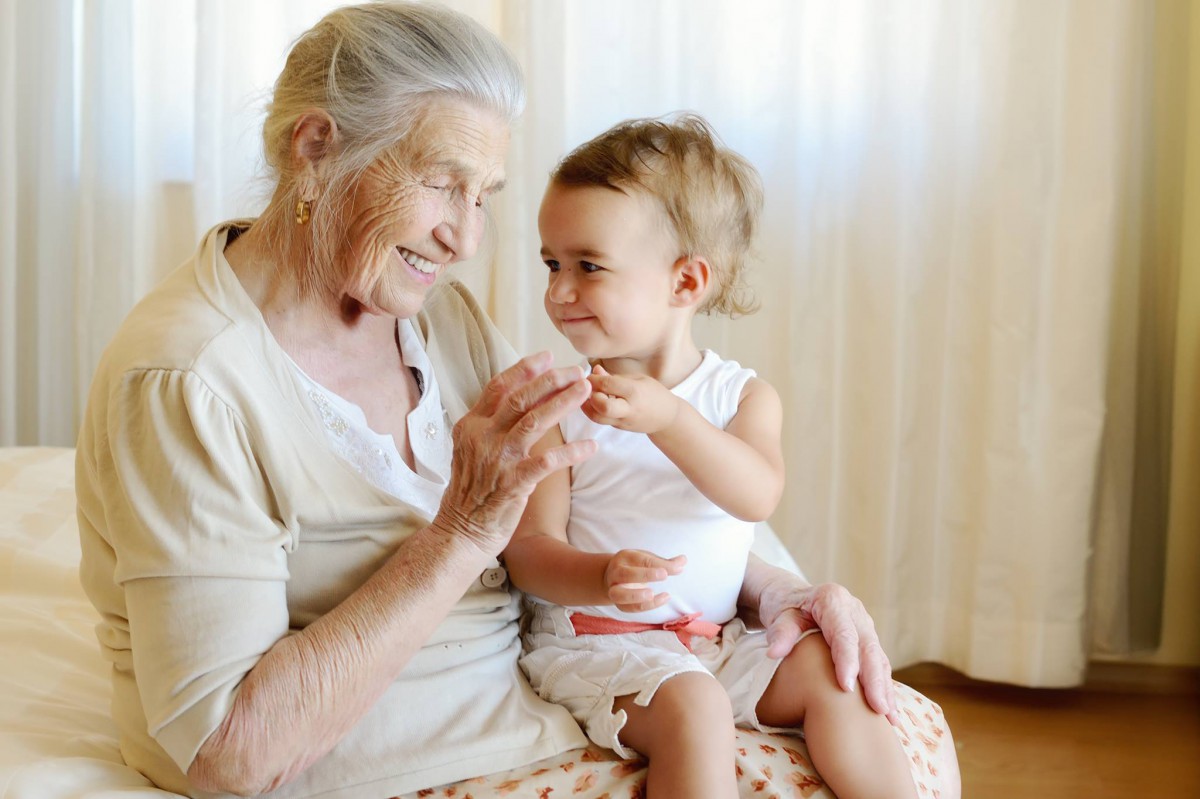 A grandmother and child sharing a joyful moment together indoors.