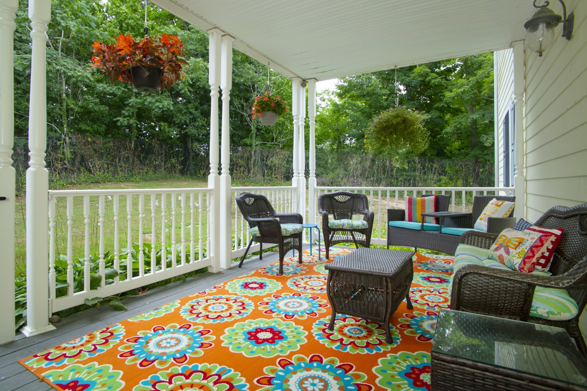 A cozy porch with colorful decor and comfortable seating.