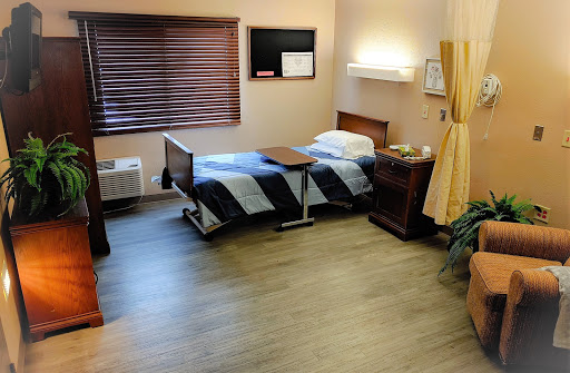 A clean and simple hospital room, featuring a bed and minimal furniture.