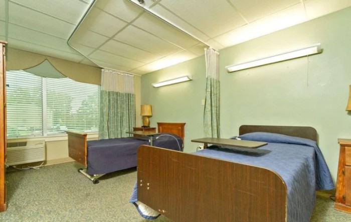 A hospital room with two beds and a partition curtain.