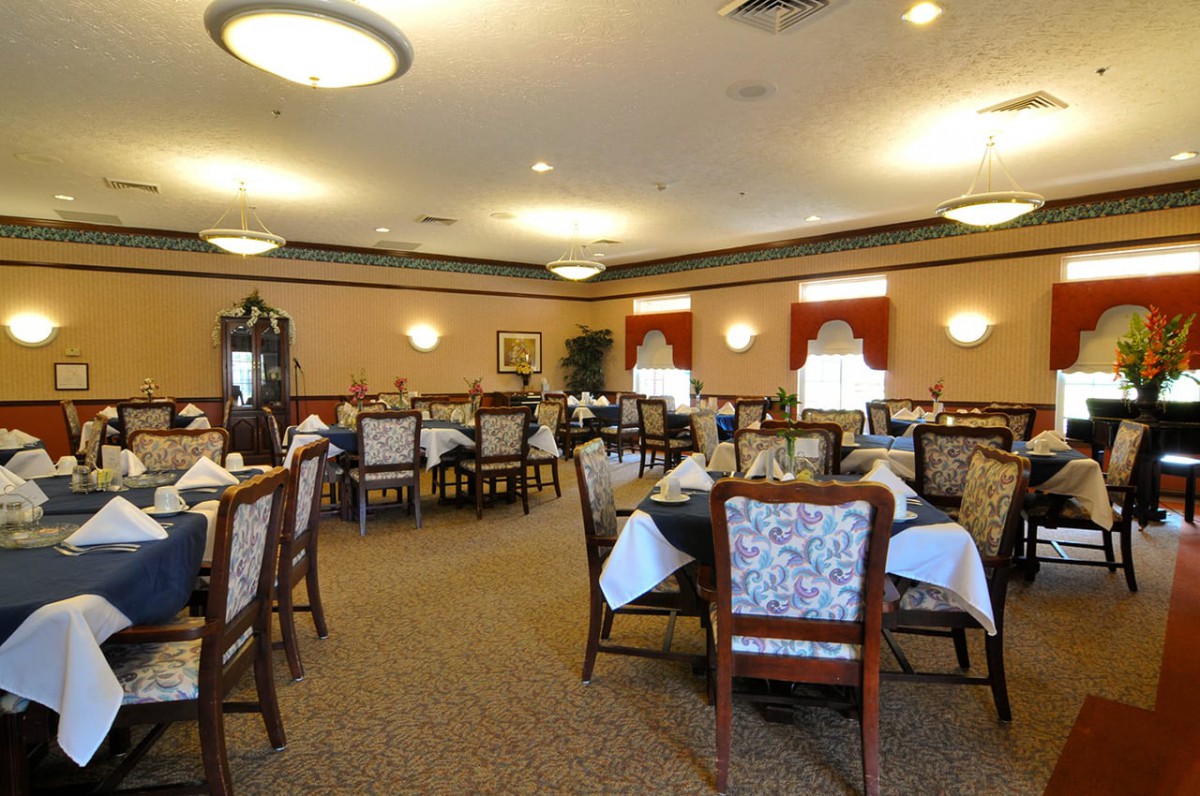 An elegantly set dining room with neatly arranged tables and chairs, ready for guests.