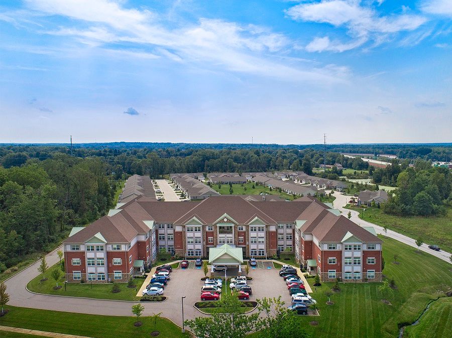 Aerial view of a large residential building with a surrounding suburban landscape.