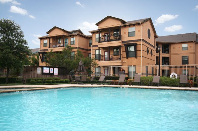 A view of residential apartment buildings with a swimming pool in the foreground.
