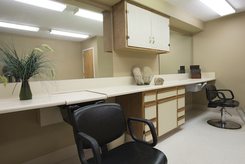 A clean and organized workspace featuring a chair and counter with storage.