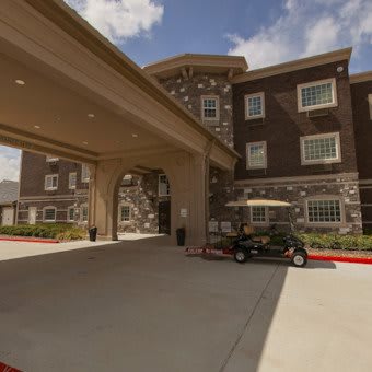 The entrance of a hotel with a golf cart parked nearby.