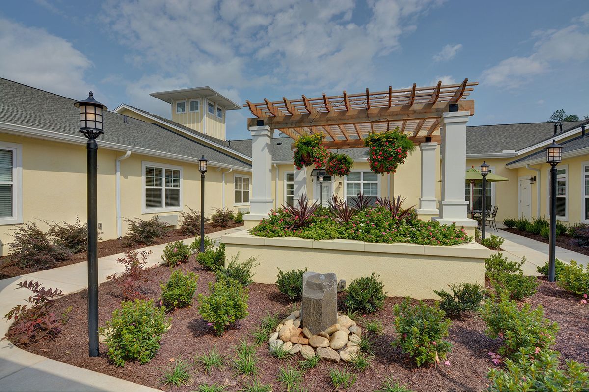 A well-maintained garden with a pergola and building exterior.