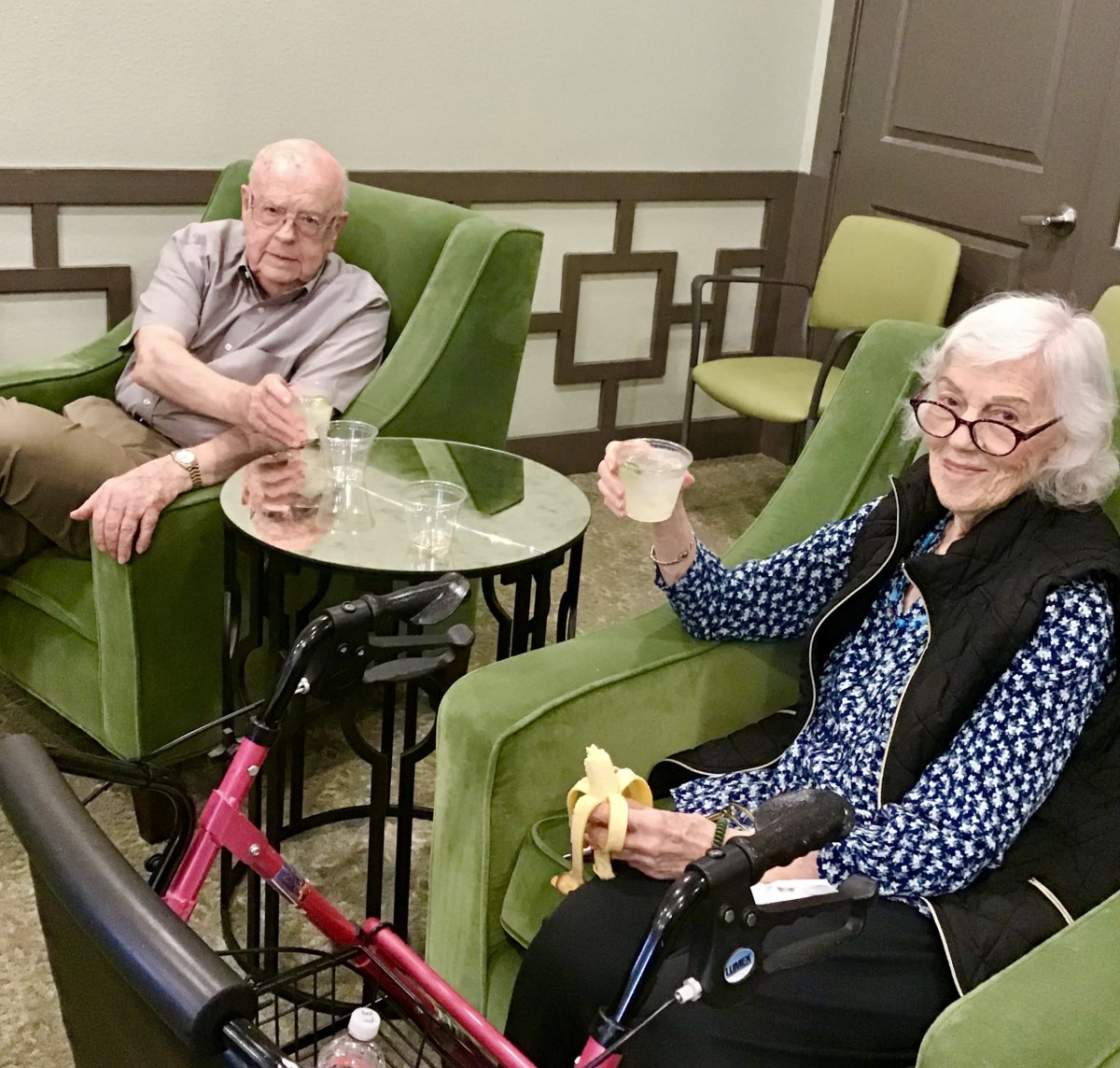 Two senior individuals relaxing in a comfortable seating area.