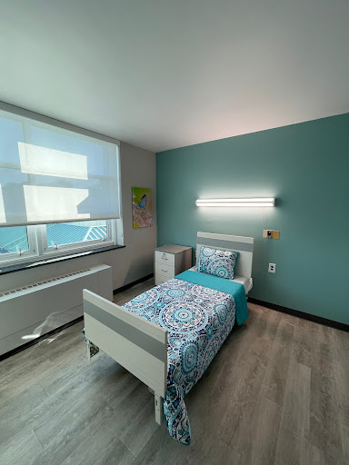 A cozy modern bedroom featuring a single bed, a soothing color palette, and ample natural light.