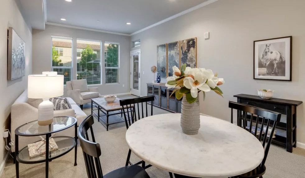 A modern living and dining area with a marble table and elegant decor.