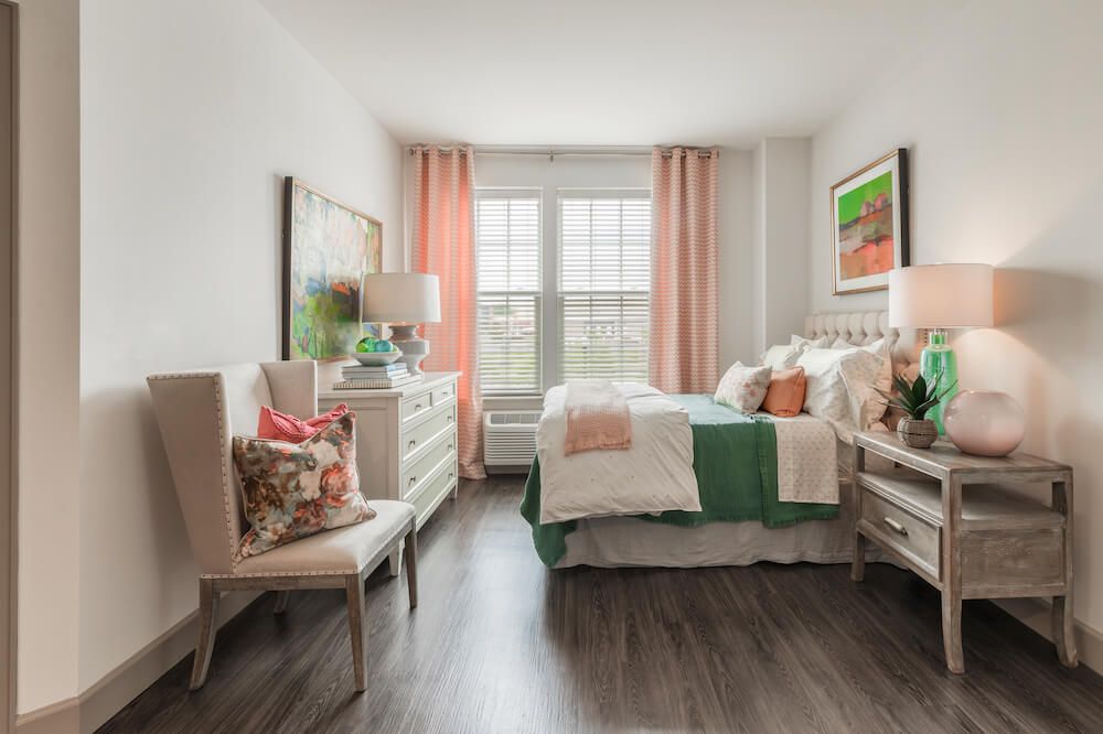 A modern bedroom with elegant decor and large windows.