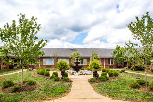A serene courtyard featuring a fountain, lush greenery, and a welcoming pathway.