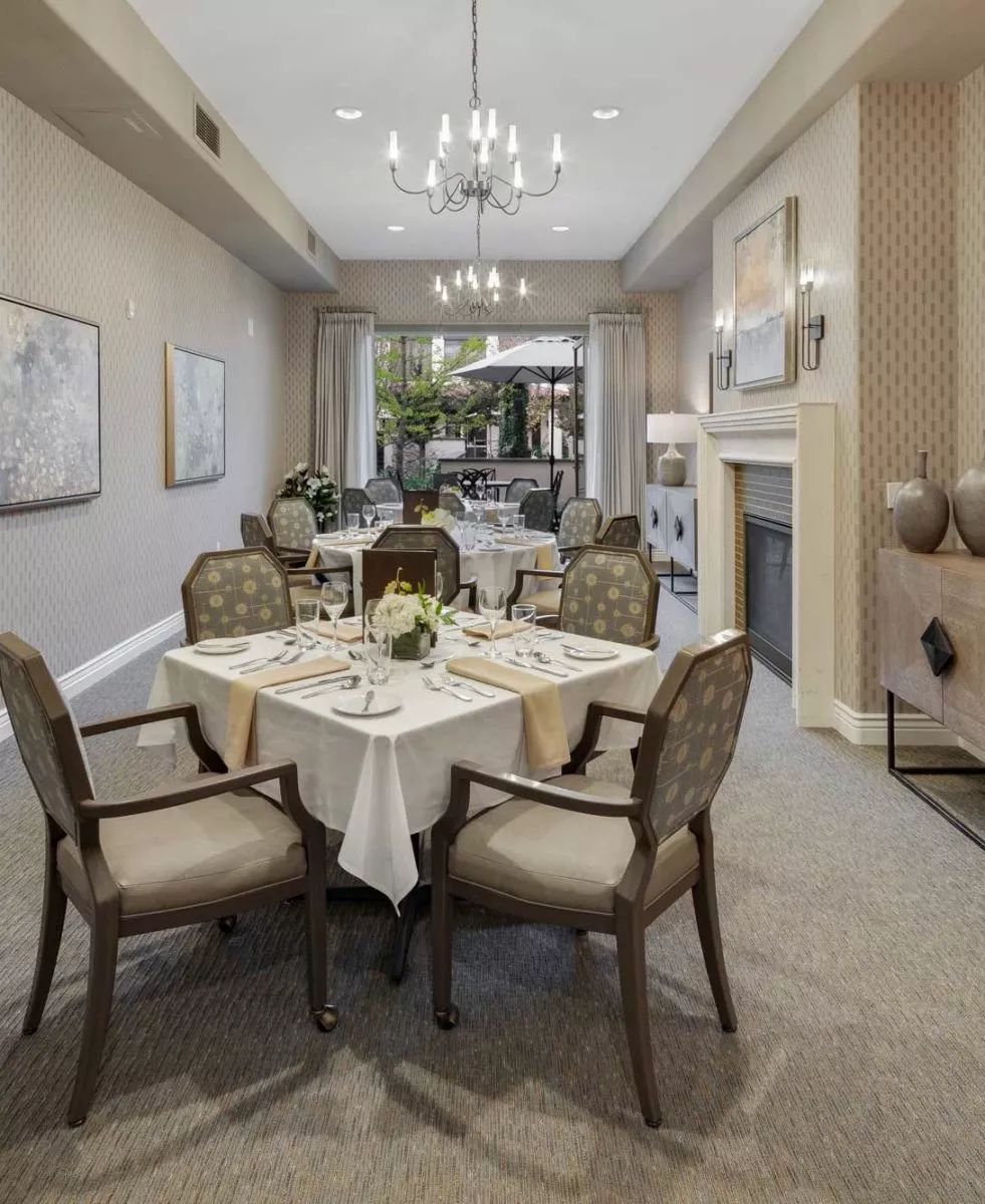 An elegantly set dining room with a sophisticated interior design and chandeliers.