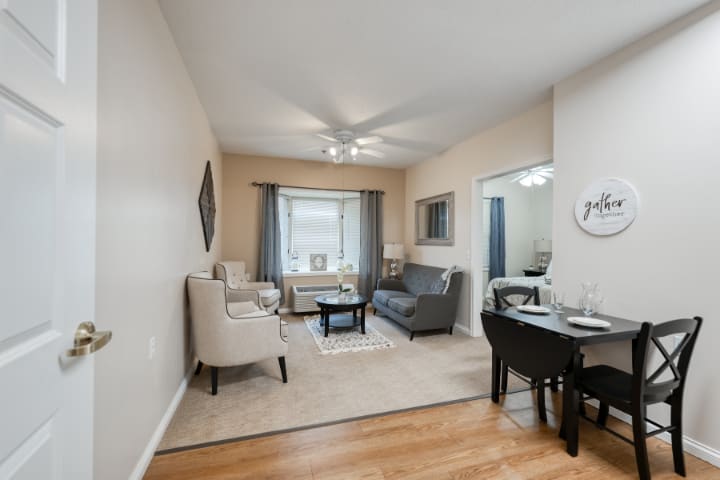 A cozy living room with comfortable seating, a dining table, and soft natural light.