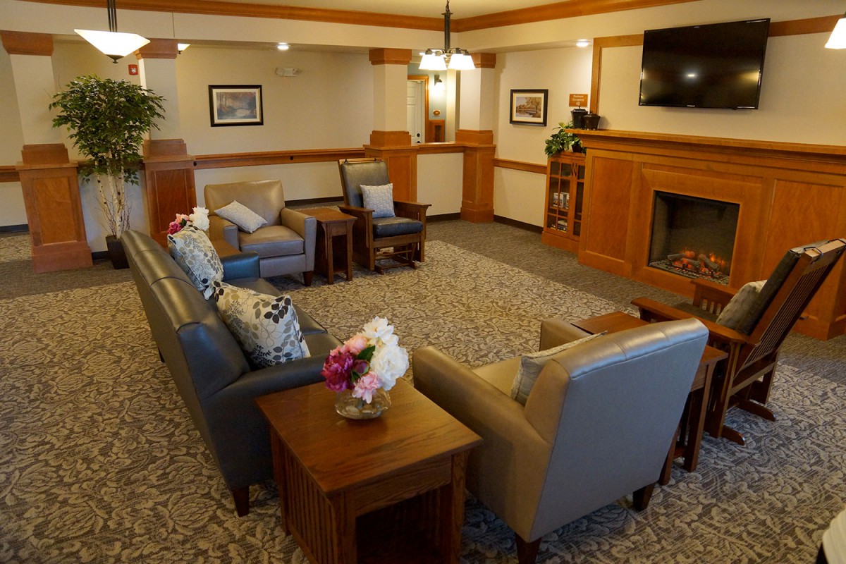 A cozy living room with comfortable seating, a fireplace, and decorative elements.