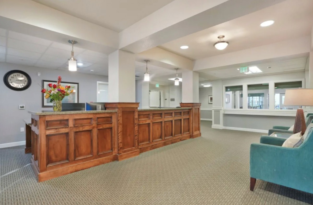 A spacious lobby with wood paneling, carpet, and modern lighting fixtures.