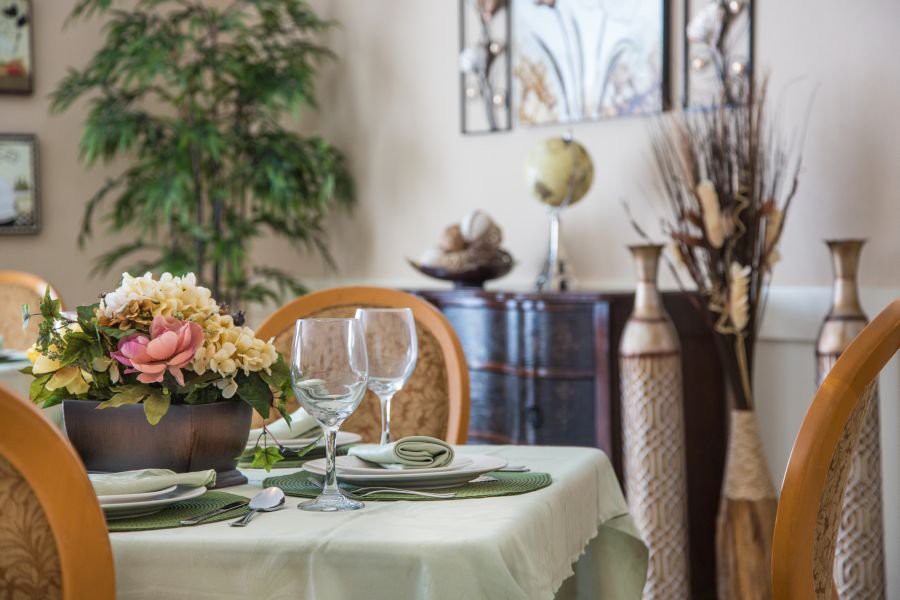 An elegantly set dining table with decorative flowers and glassware in a stylishly decorated room.