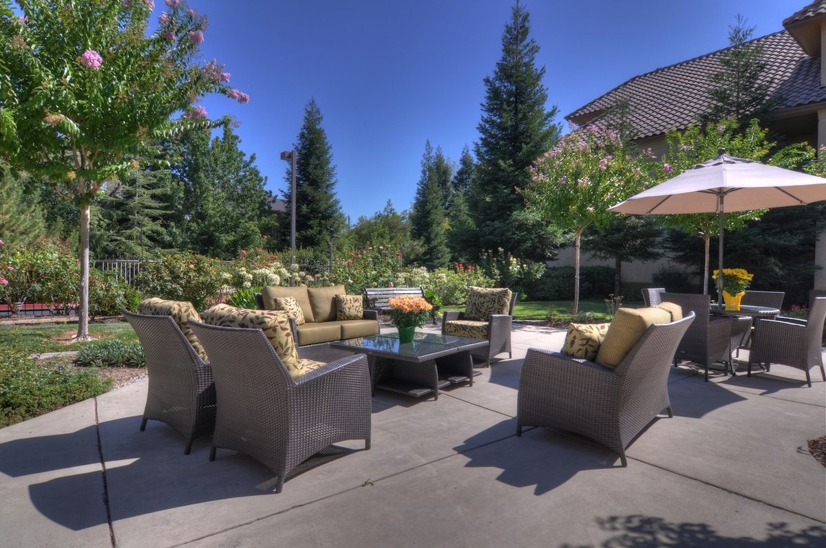 A beautiful outdoor patio area with comfortable seating and lush greenery.