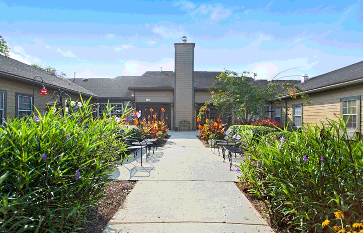 A well-maintained courtyard with a central pathway, surrounded by lush landscaping and outdoor seating.
