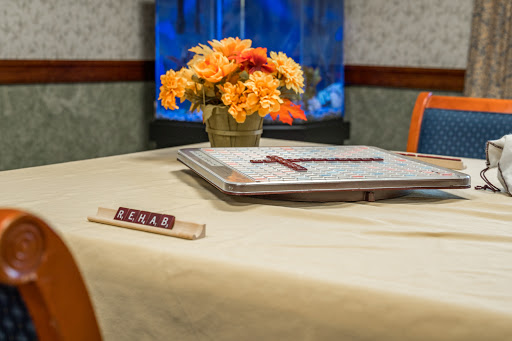 A cozy game night setup featuring a floral centerpiece and game tiles on a well-set table.