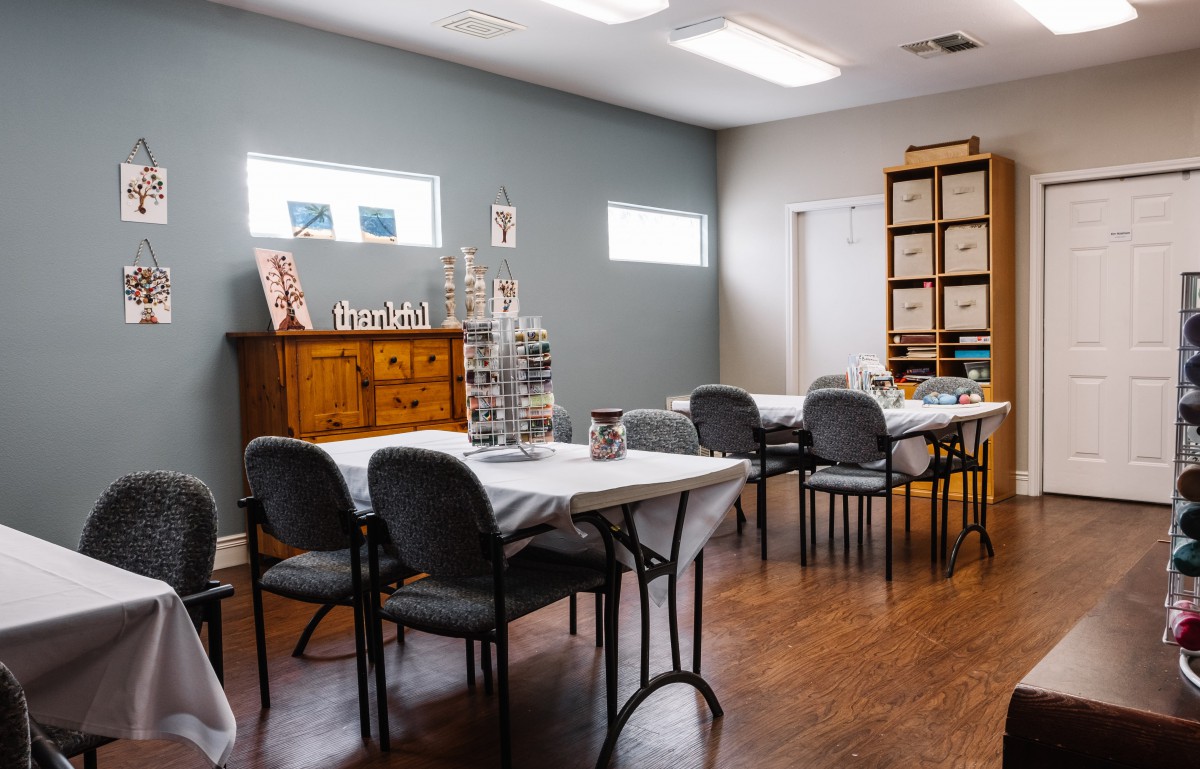 An art studio with tables and chairs set up for a creative workshop.