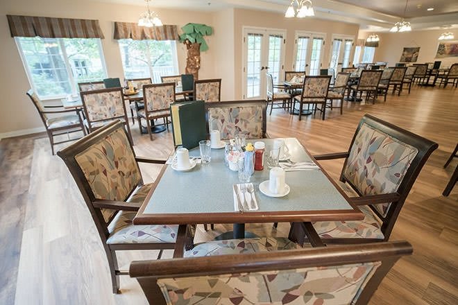 A neatly arranged dining area with tables and chairs set for a meal.