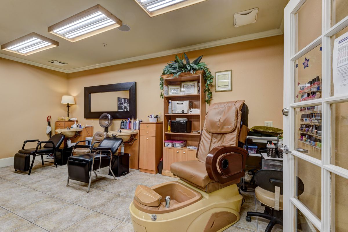 A cozy spa salon room featuring a pedicure massage chair and beauty equipment.