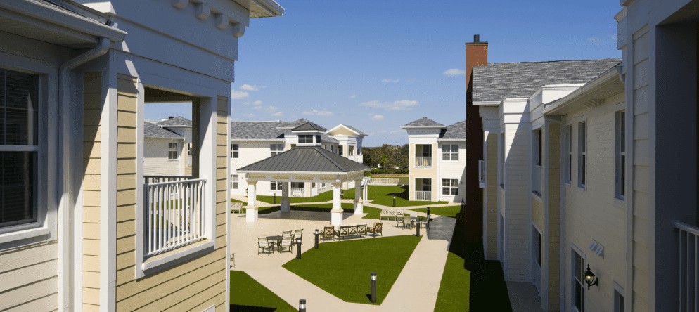 A view of a residential apartment complex featuring landscaped courtyards and a central gazebo.