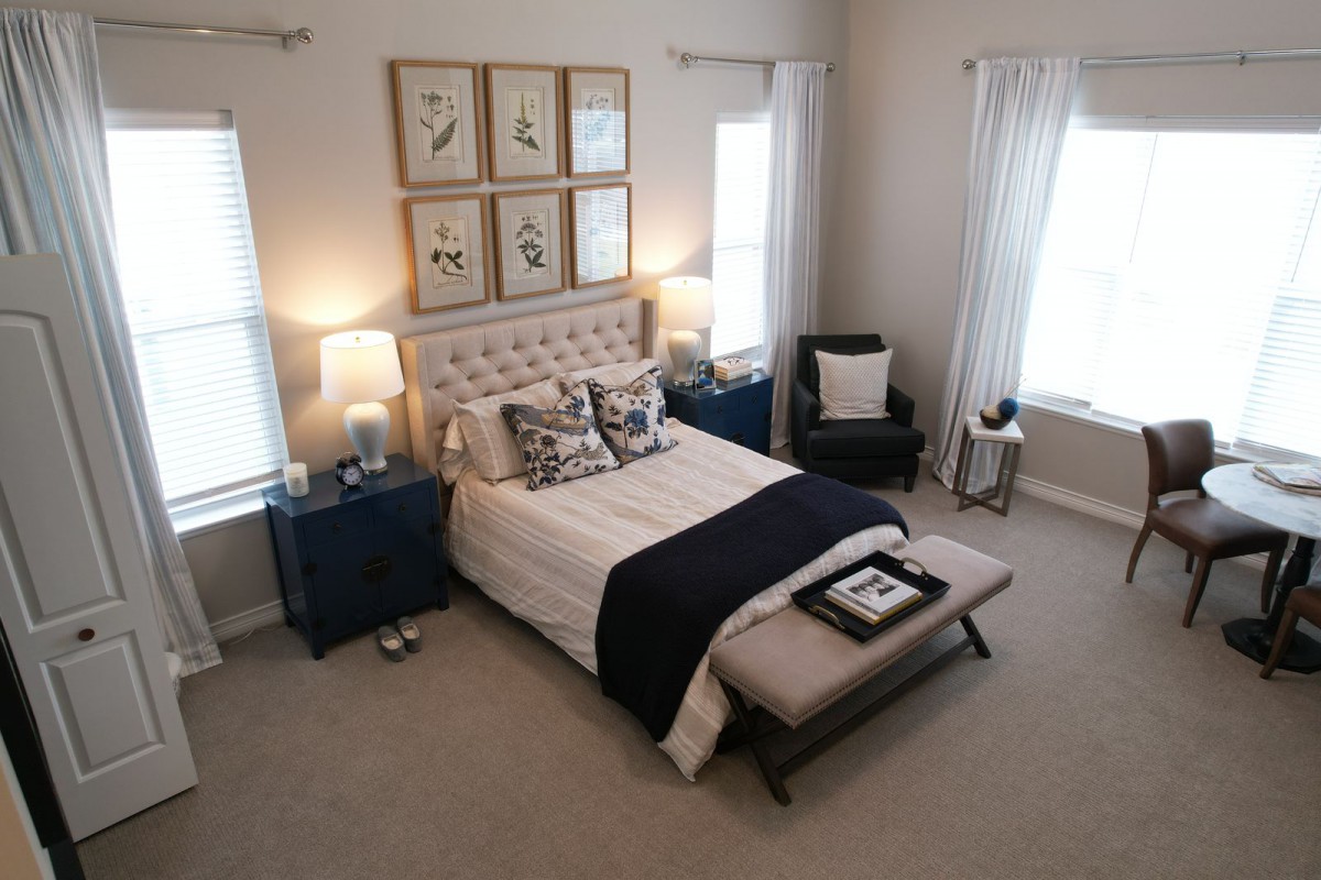 A modern and cozy bedroom with elegant decor, featuring a plush bed, stylish nightstands, and soft lighting.