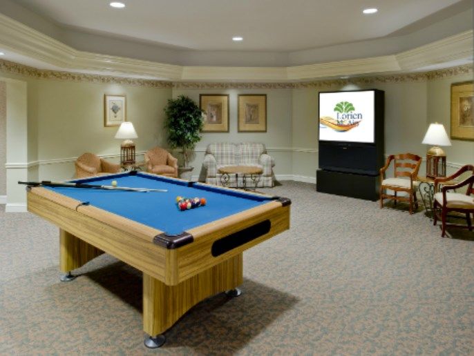 A cozy game room featuring a pool table and a seating area with decorative elements.