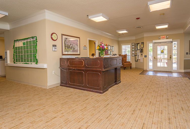 A spacious lobby with a wooden reception desk and decorative elements.