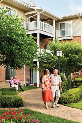 Elderly couples enjoying a walk in a retirement community's garden.
