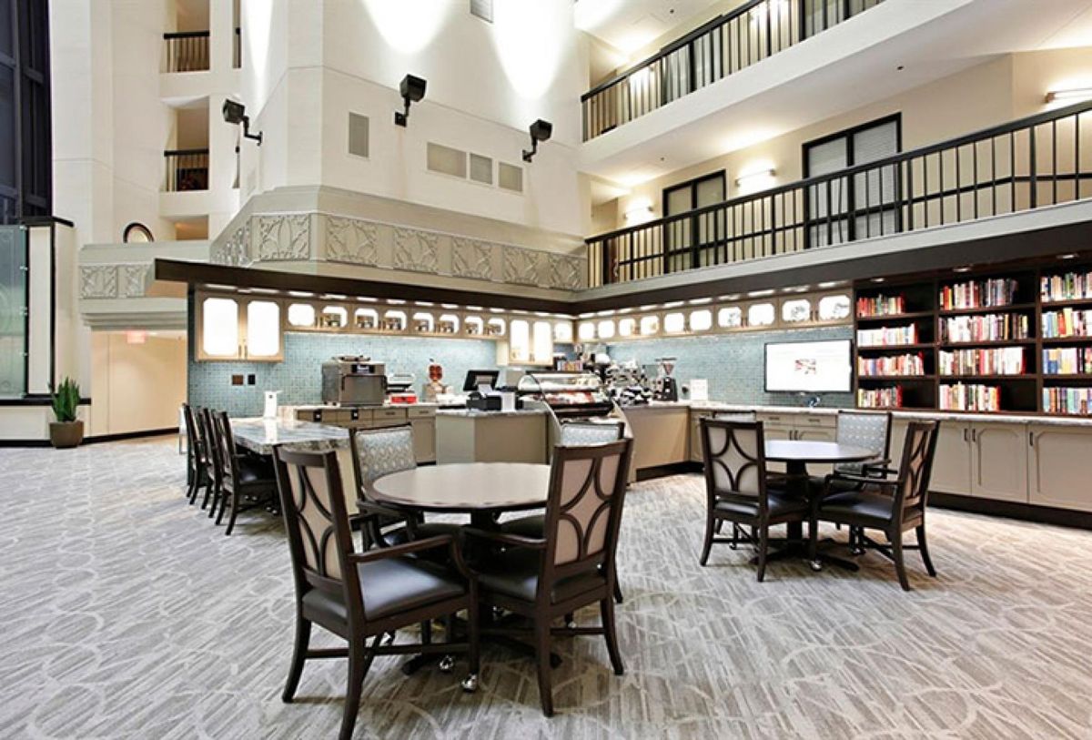 A modern indoor cafe with tables and chairs, featuring elegant lighting and interior design.