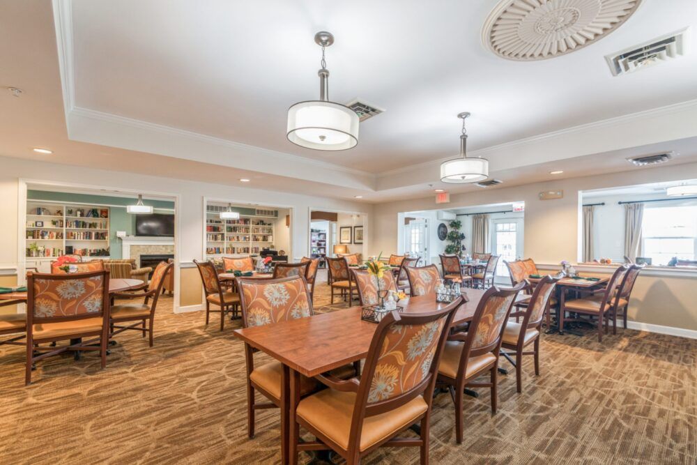 A spacious dining room with neatly arranged tables and chairs, featuring modern lighting and a welcoming atmosphere.