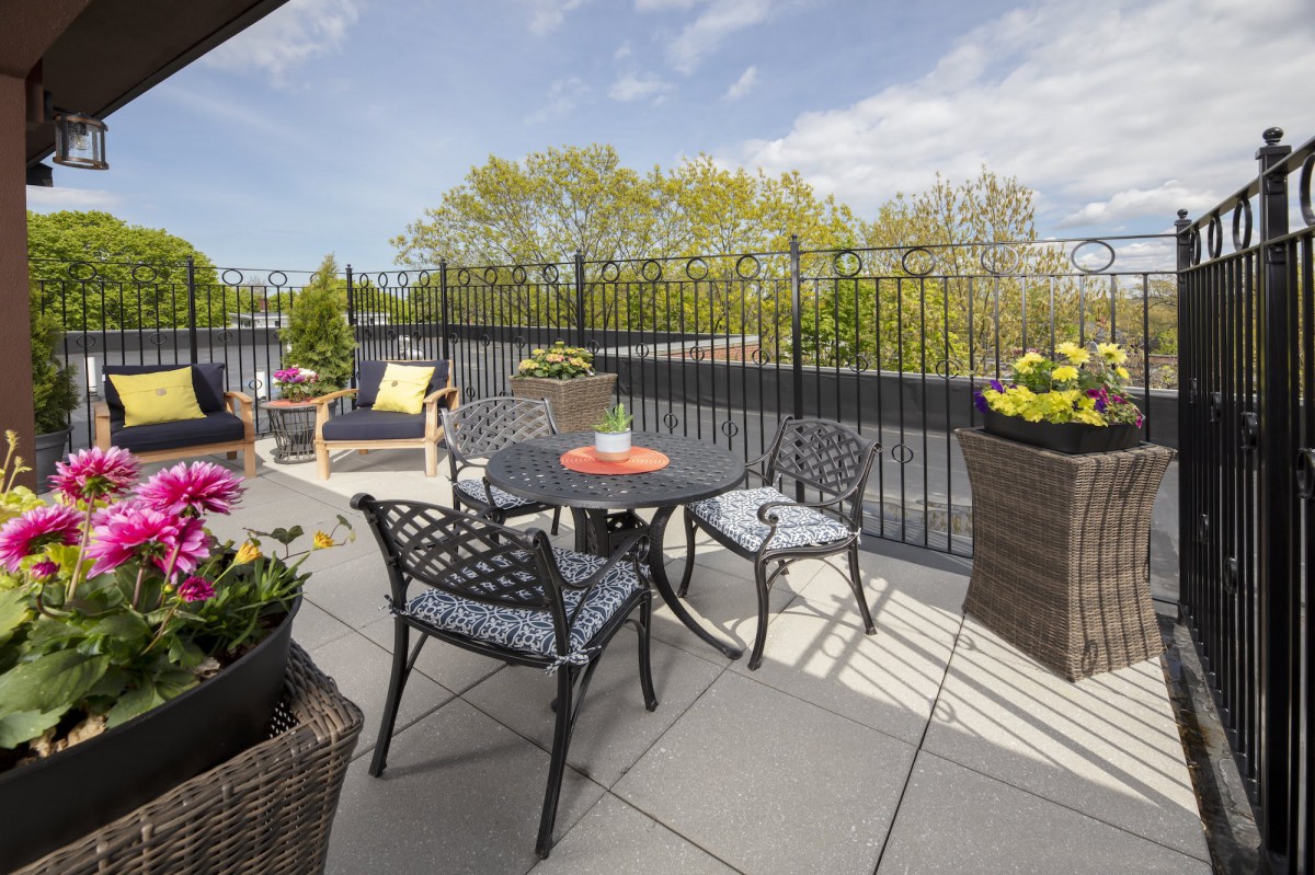 A sunny patio with outdoor furniture and potted plants.