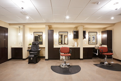A modern barbershop interior featuring stylish chairs and mirrors.